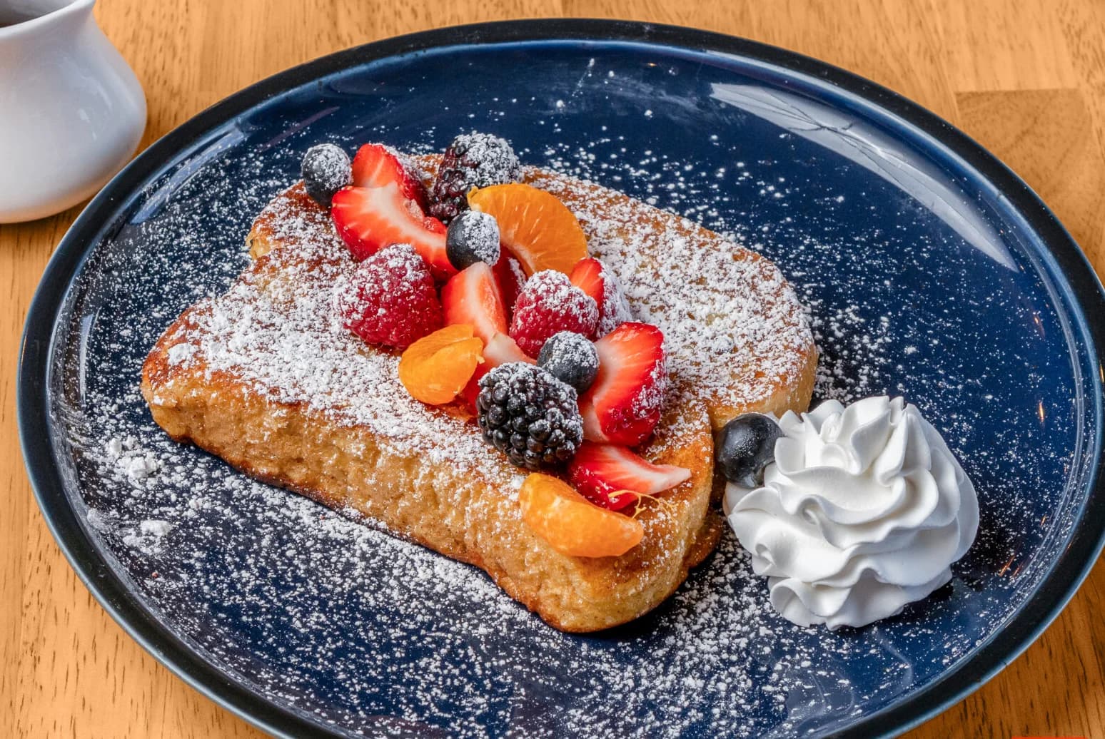 Close-up of Floré French toast topped with berries and whipped cream