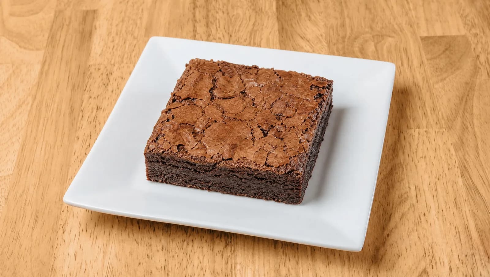 Classic chocolate brownie on a square white plate at Floré Café & Kitchen