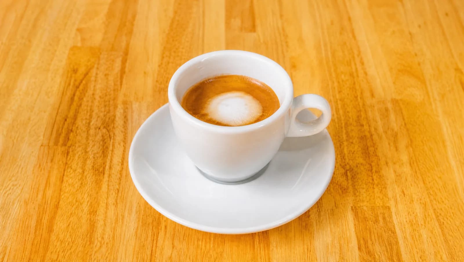 Macchiato in a small white cup at Floré Café & Kitchen | Café macchiato em xícara pequena branca no Floré Café & Kitchen