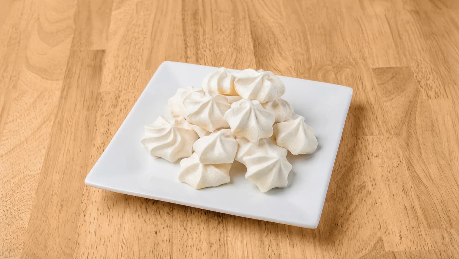 Small white meringues on a plate at Floré Café & Kitchen | Suspiros pequenos brancos em prato no Floré Café & Kitchen