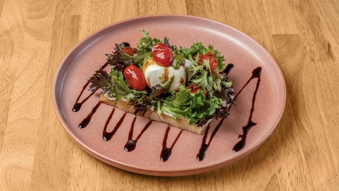 Italy Toast served on a rose-colored plate with balsamic drizzle