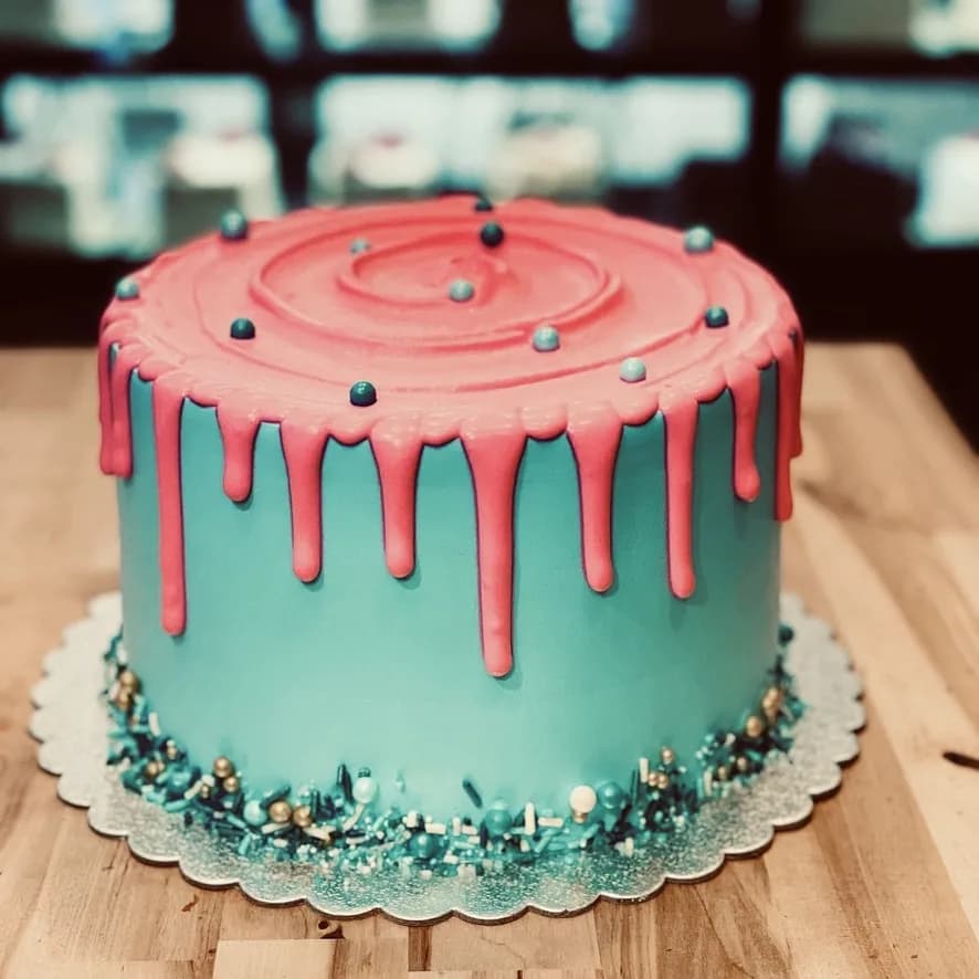 Teal celebration cake with pink drip icing and sprinkles