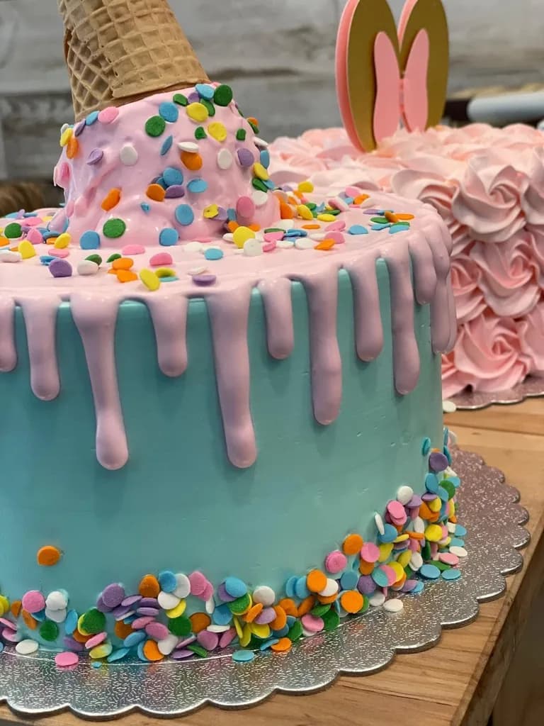 Pastel drip cake with ice cream cone and colorful confetti decoration